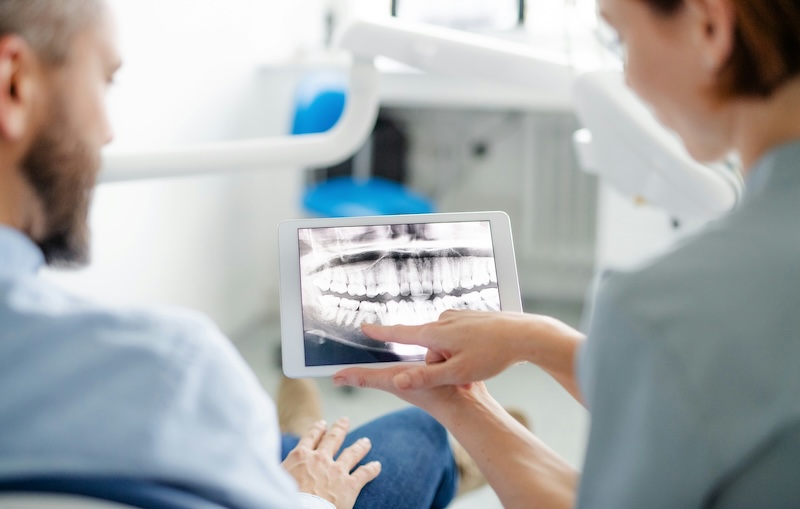 dentist reviewing digital dental X-ray with patient