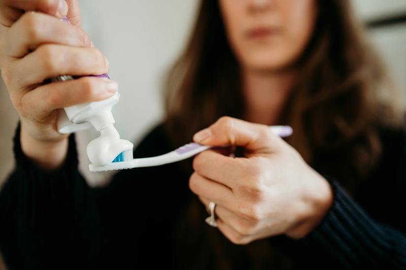 Woman putting toothpaste on a toothbrush